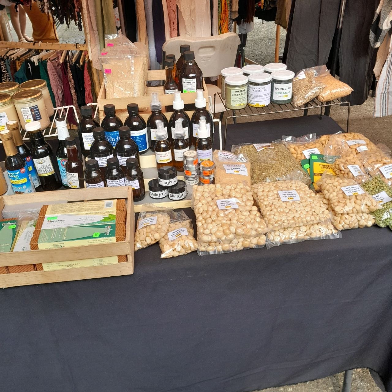 Holistic Hub market table with oils, tinctures, macadamias and cashews in labelled bags
