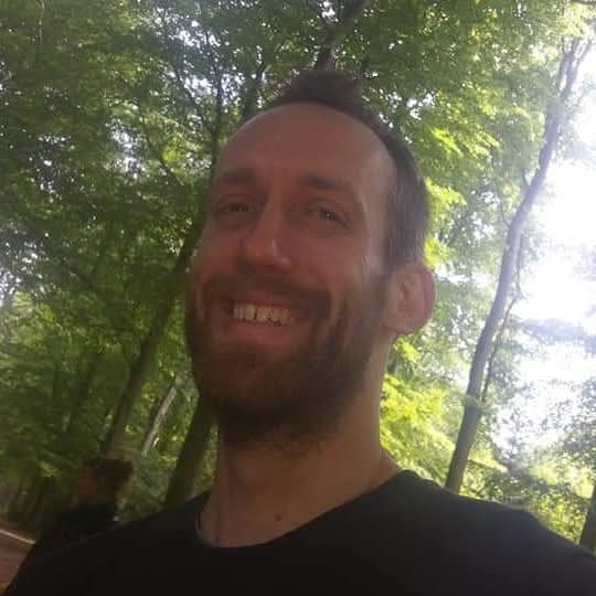 James, Holistic Hub's herbalist and nutritionist, smiling among the trees